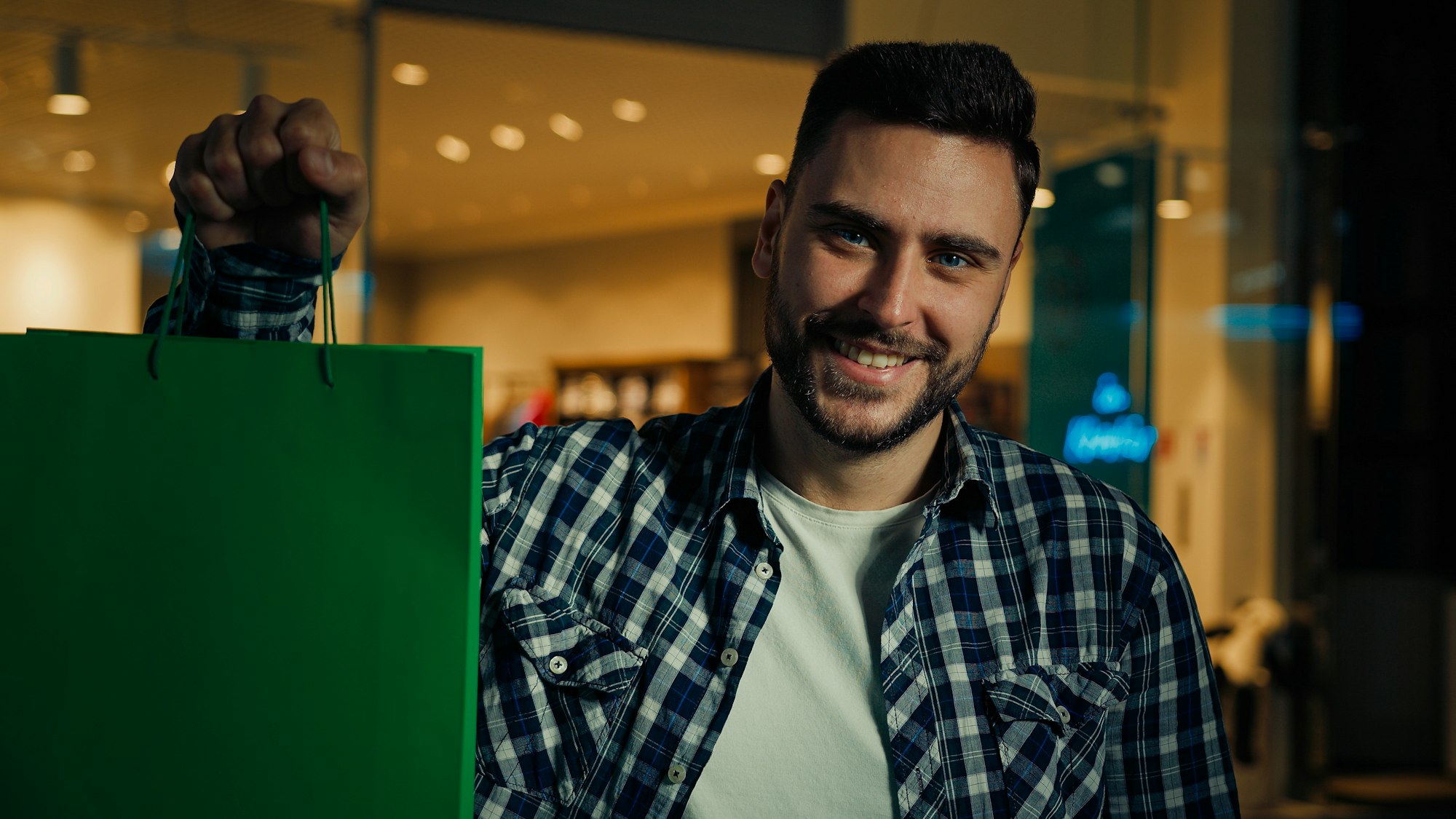 Happy customer arabian hispanic man shopper buyer shopaholic standing in shopping mall buying trendy